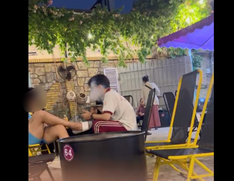 Một số thanh thiếu niên hút thuốc lá điện thử trong quán cà phê trên địa bàn phường Hiệp Phú, TP Thủ Đức (hình ảnh cắt từ clip quay vào tối ngày 12/4).